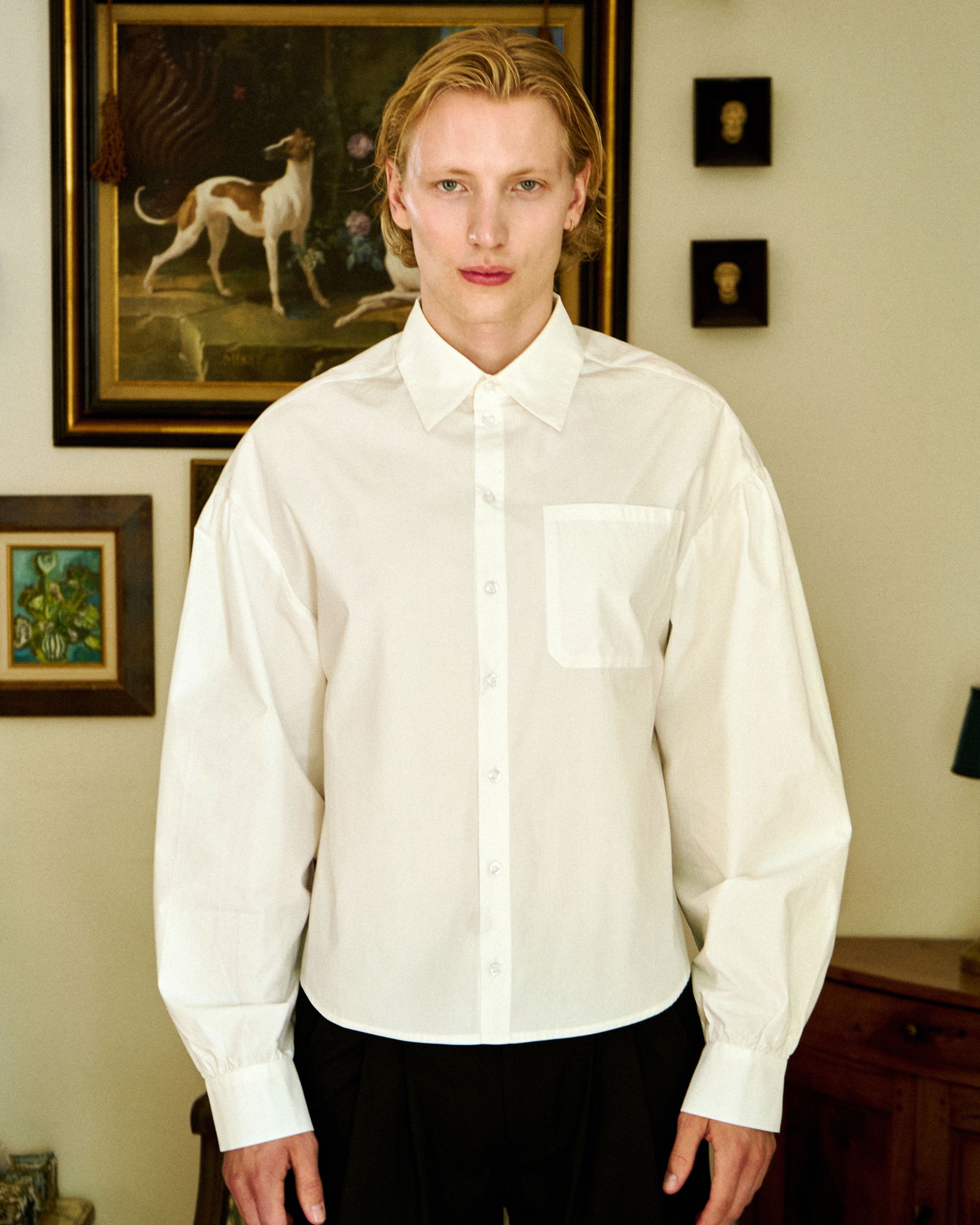 Unisex white button-up shirt with a pocket, modern Parisian style.